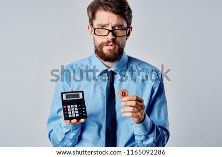 calculator and coins in the hands of a man in glasses                           