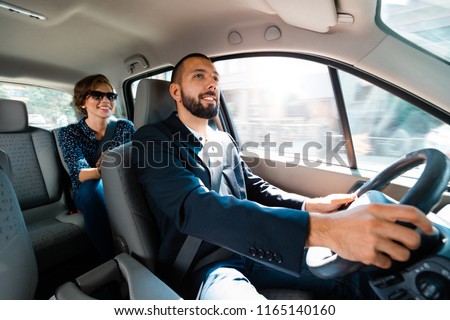 Smiling driver talking with elegant businesswoman. Royalty-Free Stock Photo #1165140160