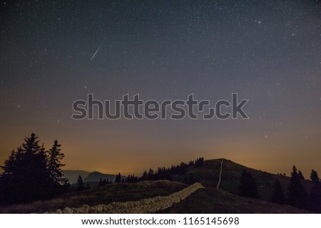 Starry Night Sky and Shooting Stars over Mountains