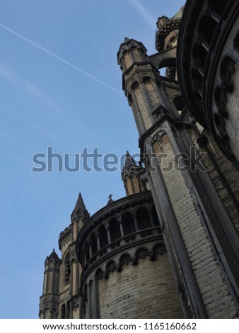 A massive gothic building rises tall between the bright blue skies, making a strong statement.