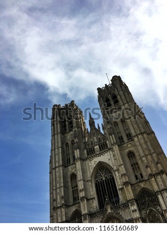 A massive gothic historical building rises tall between the bright blue skies, making a strong statement.