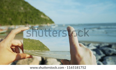 Traveler woman taking photographs sea with smartphone.