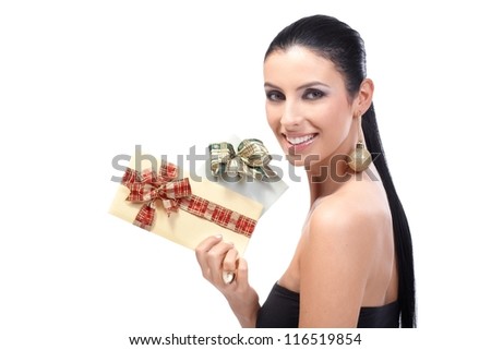Attractive young woman holding fancy Christmas envelopes tied by ribbon, wearing Christmas ornament in ear, smiling.