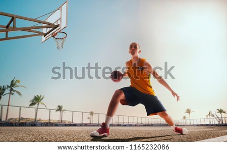 Streetball. Basketball player in action on sunset. Basketball players play in streetbol.