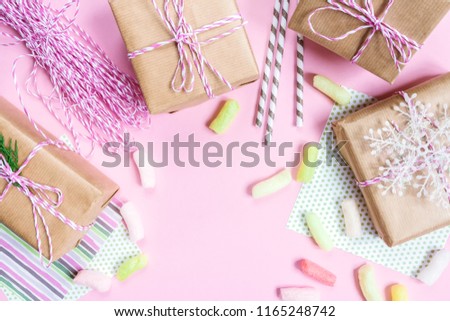 Boxes with gifts in festive packing preparing for holiday christmas birthday on pink background top view with copy space