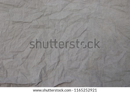 Crumpled linen fabric texture of coarse gray fabric, burlap background in close up, weave threads, fabric after washing, un-ironed canvas Royalty-Free Stock Photo #1165252921