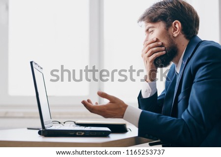 puzzled man looking at laptop                         