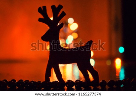 Christmas decor: deer made of felt on the background of lights