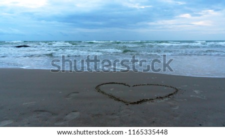Heart draw draws on the sand at sea. Express love