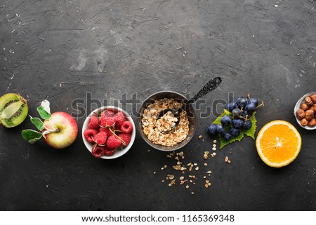 Ingredients for healthy breakfast meals: raspberries, blueberries, nuts, orange, bananas, grapes blue, green, apples, kiwi. Top View