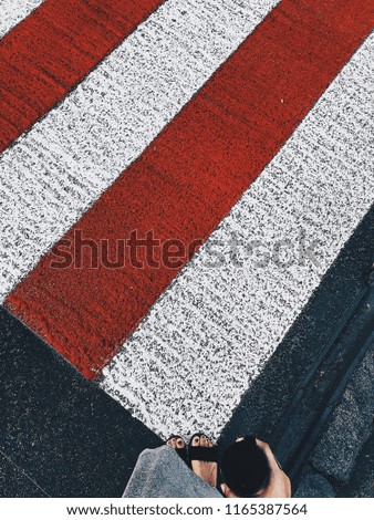 The girl is standing at a pedestrian crossing. View from above. Vertical shot