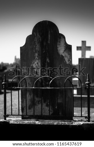 Dramatic old Tombstone in a graveyard black and white 