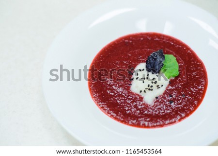 cream soup made of beetroot, with sauce cauliflower, black sesame, violet and green basil, stock photo image