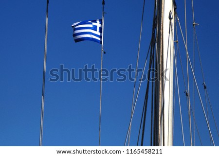 Greek flag on the mast of a sailing boat. Travelling in the blue sea, summer in Greece.