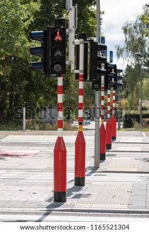 Red and white striped traffic light in a row, Red for pedestrians and bicycles.