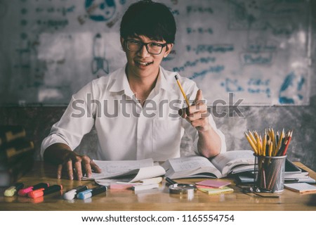 Young Asian student man sitting at desk in home studying and reading, doing homework and lesson practice preparing exam to entrance, education concept.