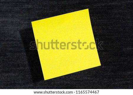 One yellow paper stickers hanging in the air (levitate) on blue jeans background
