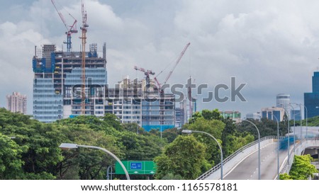 Construction site of a modern skyscraper in Singapore timelapse. Aerial view from above. Clouds on background