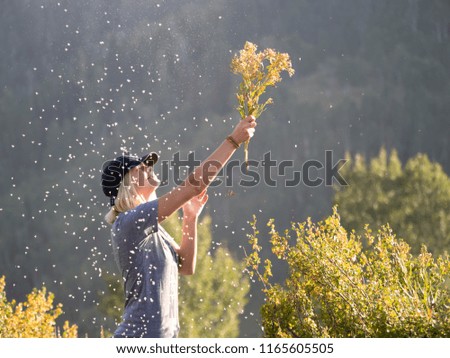 Girl waving wild flowers into the air