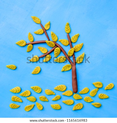 Plasticine yellow autumn tree on a bright blue background