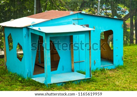 Wooden doghouse on a green meadow