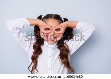 Portrait of nice cute cheerful adorable lovely stylish girl with curly pigtails in white blouse shirt, showing ok-signs like eyewear. Isolated over grey background