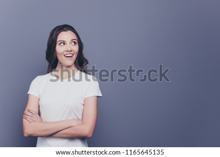 Attractive pretty adorable wondered stylish curly-haired girl in white t-shirt, folded arms, isolated over grey background, copy space