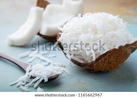 Coconut flakes in a shell on a blue background Royalty-Free Stock Photo #1165662967