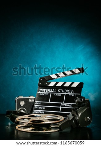 Vintage film claper with film reel and camera. filmmakers equipment background