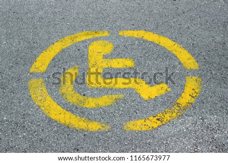 Disabled persons no parking sign yellow on grey asphalt 
