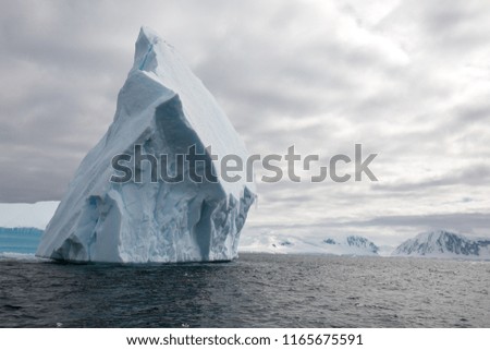 icecaps in the Antarctica with iceberg in the ocean swimming around and melting in the sea