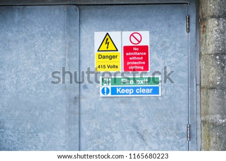Danger high voltage keep clear fire exit sign on metal door