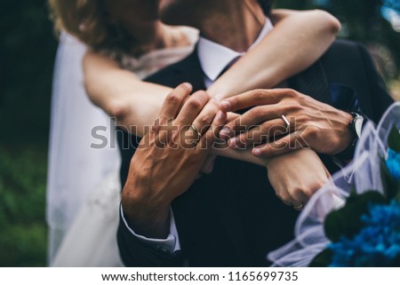 a wedding ceremony and a walk with a photo session of two lovers, the newlyweds hug and love each other, the gentle touches of the hands of the bride and groom with engagement rings, the beauty love