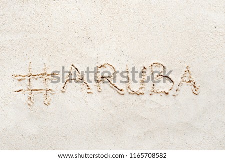Handwriting words "Aruba" on sand of beach