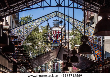 Indoor detail of the famous Food Market (La Boqueria) in the old town of Barcelona, Catalonia, Spain, Europe. Colorful patterns and ornaments on glass. Grand iron entrance the way up the Las Ramblas Royalty-Free Stock Photo #1165712569