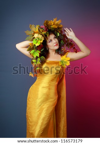 Autumn Woman. Beautiful makeup. Golden dress. Dark blue and purple color background
