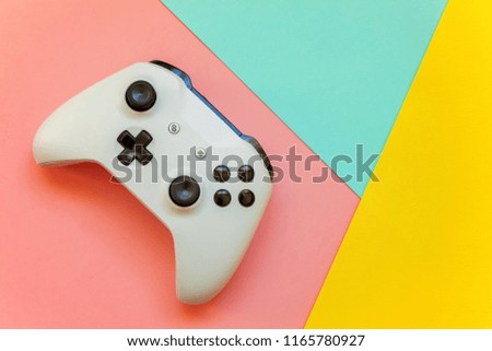 White joystick gamepad, game console on yellow, pink and blue colourful trendy modern fashion pin-up background. Computer gaming competition videogame control confrontation concept