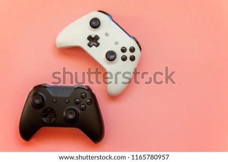 White and black two joystick gamepad, game console on pink colourful trendy modern fashion pin-up background. Computer gaming competition videogame control confrontation concept