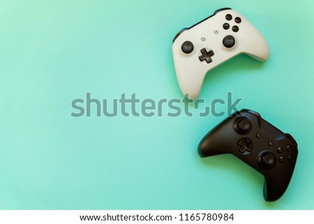 White and black two joystick gamepad, game console on blue colourful trendy modern fashion pin-up background. Computer gaming competition videogame control confrontation concept