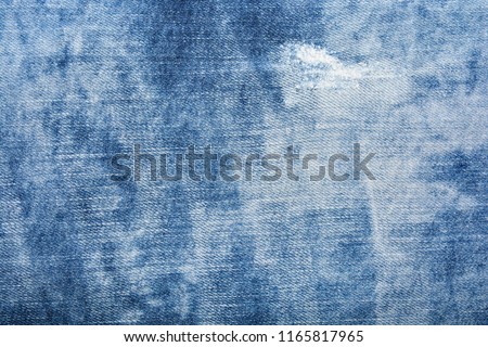 Blue denim texture with holes and threads Royalty-Free Stock Photo #1165817965