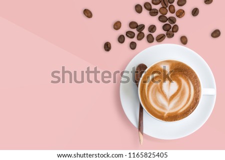 A cup of Latte coffee with scattered roasted coffee beans on pastel millennial pink tone background.  Happy coffee Latte