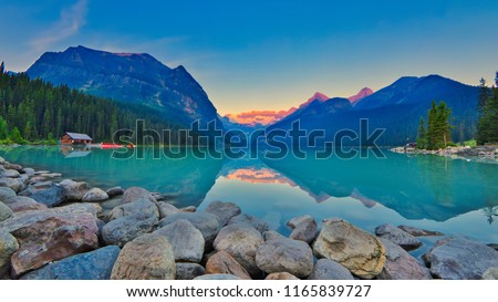 Good mornig Lake Louise.  {Panoramic view of the world famous Lake Louise from shore line to Victoria Glacier.  From the boat rental house to the shore the Chateau Lake Louise. Royalty-Free Stock Photo #1165839727