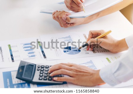 Businesswoman holding a pen pointing the graph  with partnership to analyze the marketing plan with calculator. Meeting brainstorming and discussing project. Teamwork concept. Royalty-Free Stock Photo #1165858840