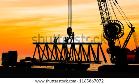 silhouette of construction workers working with crane, Royalty-Free Stock Photo #1165867072