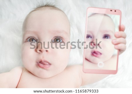 Baby girl taking selfie with a cell phone camera