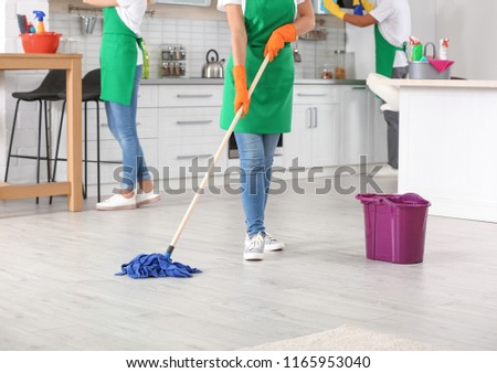 Woman cleaning floor with mop in kitchen, closeup Royalty-Free Stock Photo #1165953040