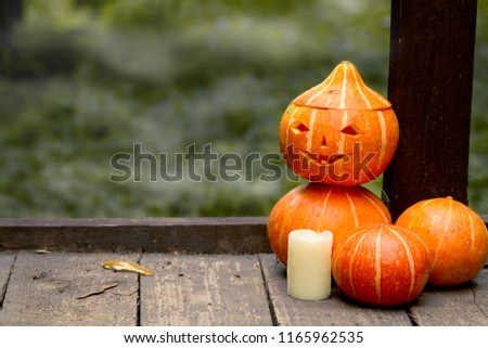 funny man of pumpkins with a carved face on a wooden old floor on the bridge in the autumn mistery Park. Concept for Halloween