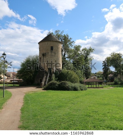 Photography that is showing an old tower in a village near the city of Macon, France