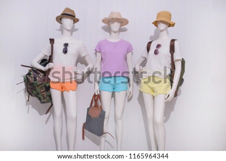Three mannequin in female shirt with blue ,yellow ,orange  trousers jeans, handbag ,sunglasses ,bag isolated
