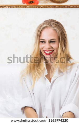 young beautiful girl with blue eyes posing on white background near picture with red poppies